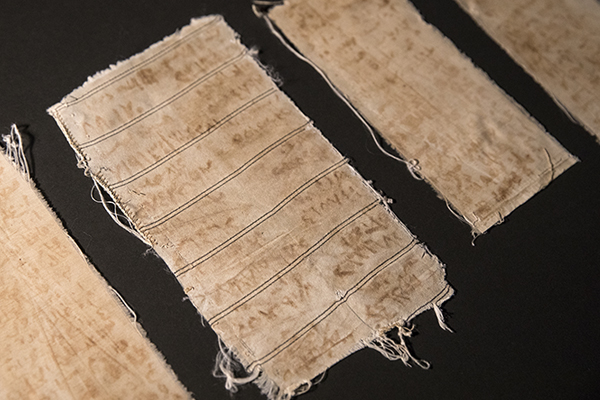 When Mansour Omari was released from prison in Syria, he smuggled out these scraps of cloth sewn within the shirt he was wearing. The names of his cellmates are written on them with an ink made from blood and rust. US Holocaust Memorial Museum&nbsp;