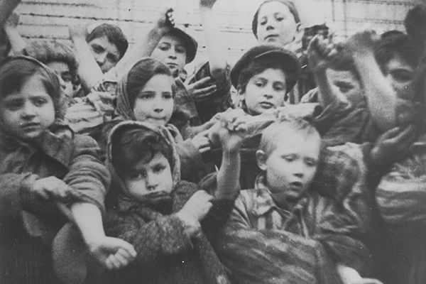 A group of child survivors of Auschwitz show their tattoos shortly after liberation. Tova Friedman is at the far left. Państwowe Muzeum Auschwitz-Birkenau w Oświęcimiu