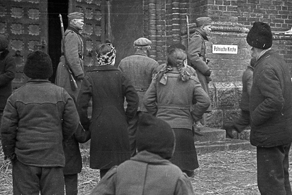 Entrance to the Church of the Sacred Heart with Volksdeutsche settlers guarded by members of the Reichsarbeitsdienst (Reich Labor Service), Turek in German-occupied Poland, March 1942. Muzeum Miasta Turku im. Józefa Mehoffera, MRZTT/HA/1073, 05-192, 195