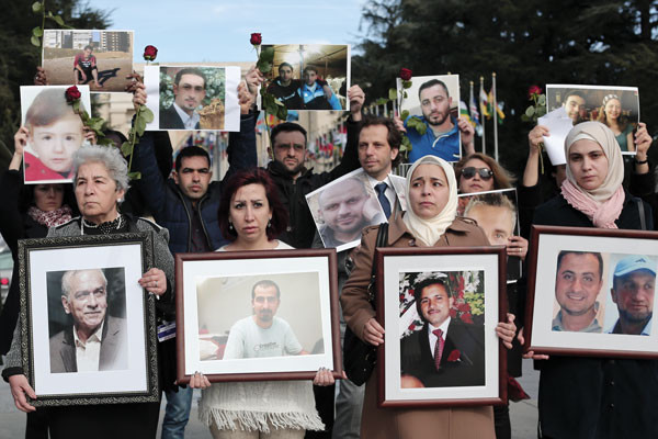 During peace talks in Geneva in February 2017, Syrians hold images of loved ones disappeared by Syrian government forces over the course of the six-year war. Dylan Collins