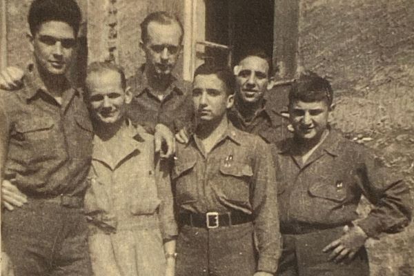 Eddie Willner (front row, second from right) survived nine concentration, labor, and internment camps, as well as two death marches. He and fellow inmate Mike Swaab (front row, far right) are shown here with members of the American tank company they encountered in April 1945. Eddie later served in the US Army, retiring as a major after 20 years. Courtesy of Albert Willner