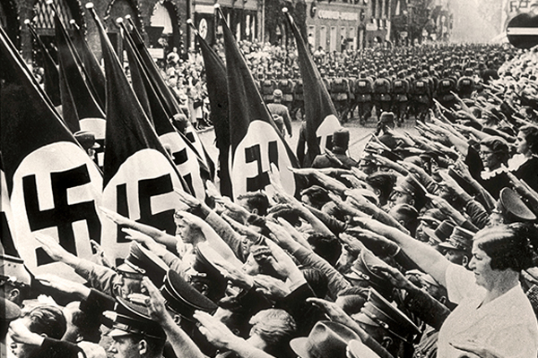 Citizens salute Hitler while attending a Nazi parade in Nuremberg, Germany, 1937. Courtesy of Shawshots/Alamy Stock Photo
