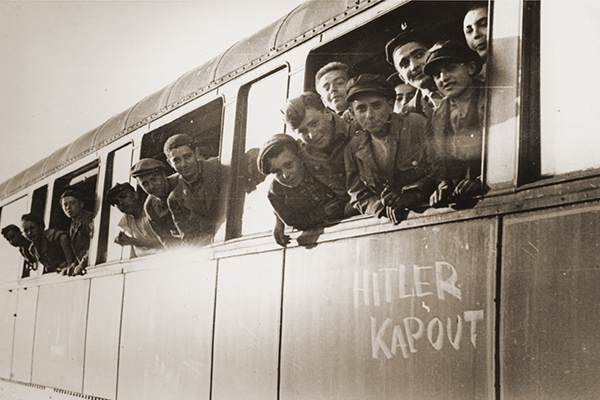 Jewish youth liberated at Buchenwald lean out the window of a train as it leaves a station to take them to a children’s home in France in June 1945. US Holocaust Memorial Museum, courtesy of Robert Waisman