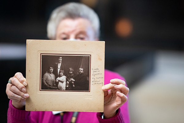 Ruth Elenberg Eisenberg, a Holocaust survivor and Museum volunteer, holds a photograph of relatives during a names reading on International Holocaust Remembrance Day. Leigh Vogel for the US Holocaust Memorial Museum